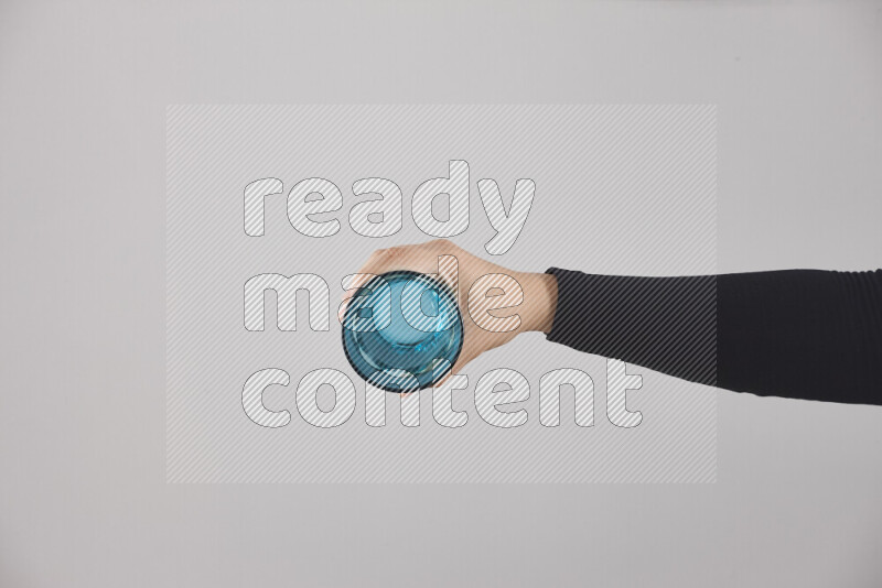 A woman in black abaya holding different glassware in different positions