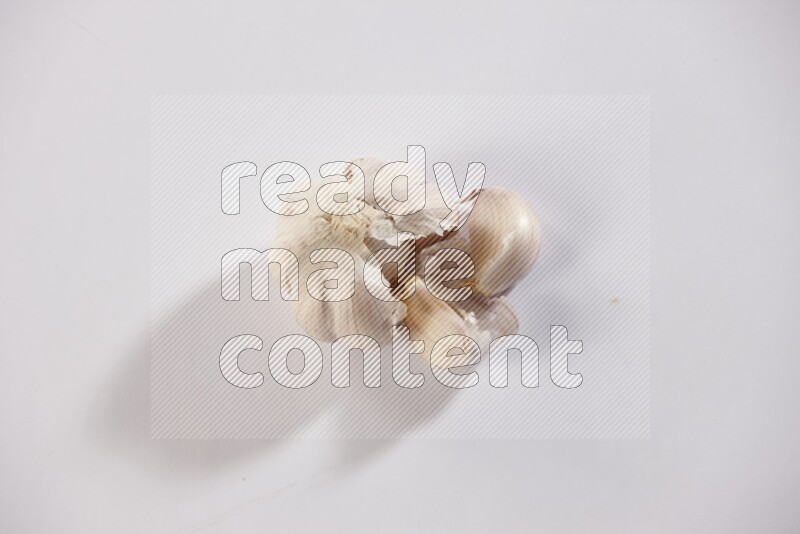 A whole garlic bulb placed on a white flooring
