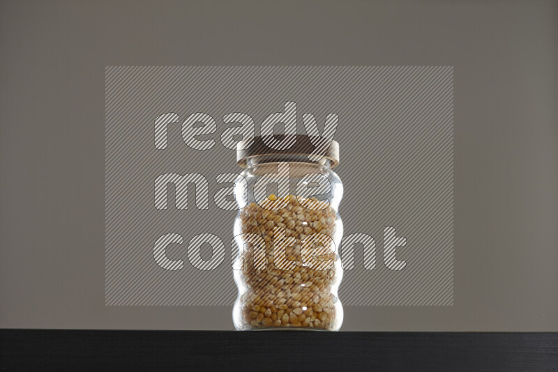 Pop corn in a glass jar on black background