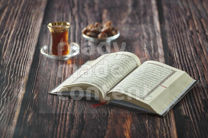 Quran with dates, prayer beads and different drinks all placed on wooden background