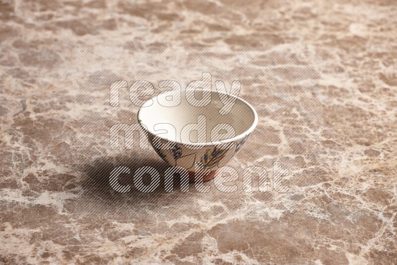 A decorative pottery bowl on beige marble background