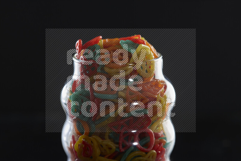 Snacks in a glass jar on black background