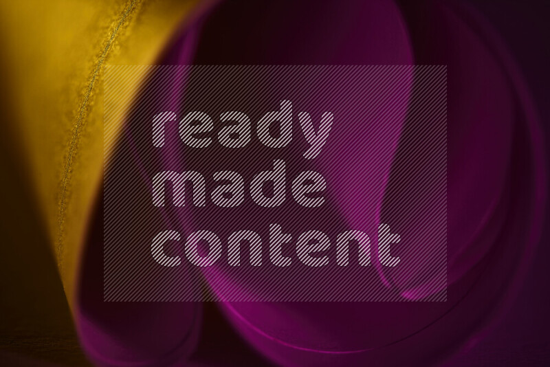 An abstract art piece displaying smooth curves in yellow and pink gradients created by colored light