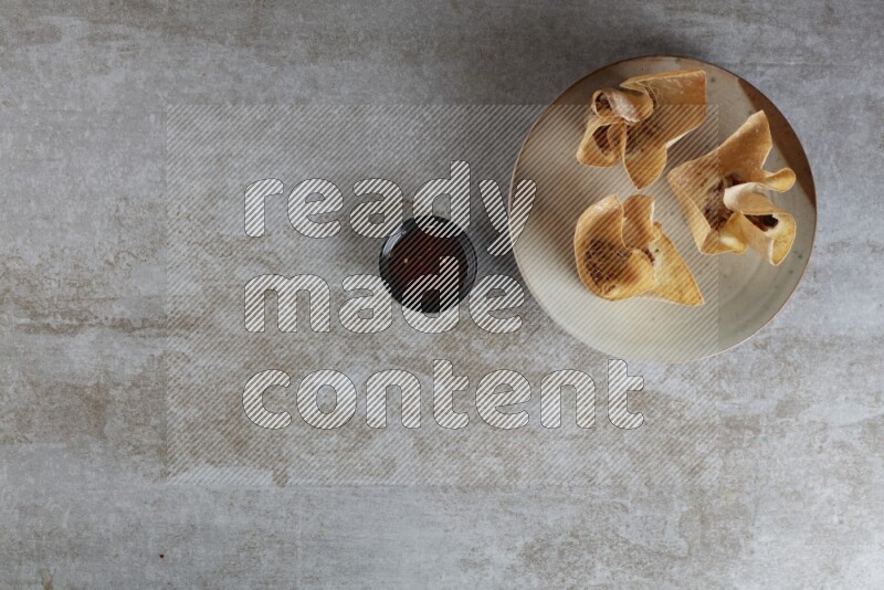 wonton cups with soy sauce ramkin on multi colored pottery on grey textured counter top