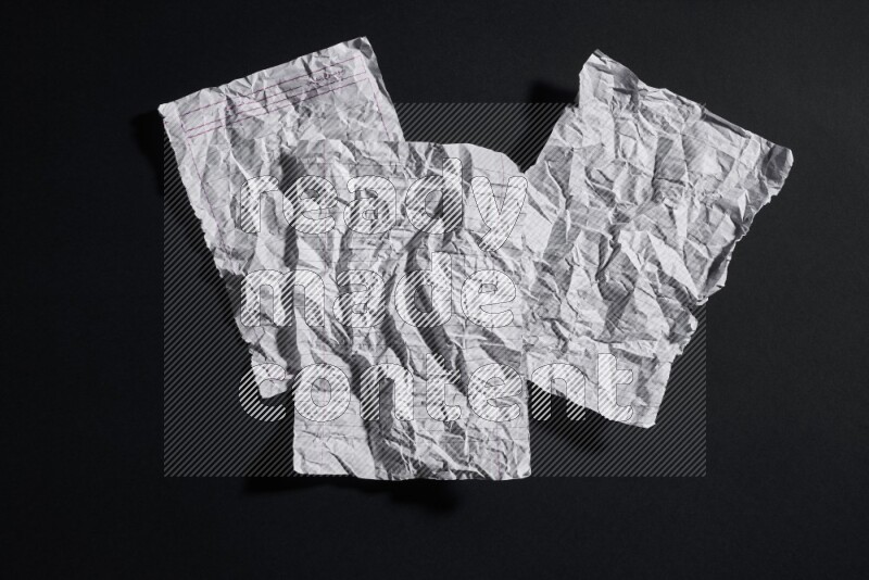 Crumpled notebook sheet on black background