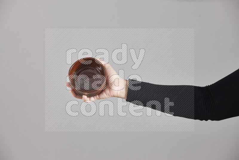 A woman in black abaya holding different pottery essentials in different positions