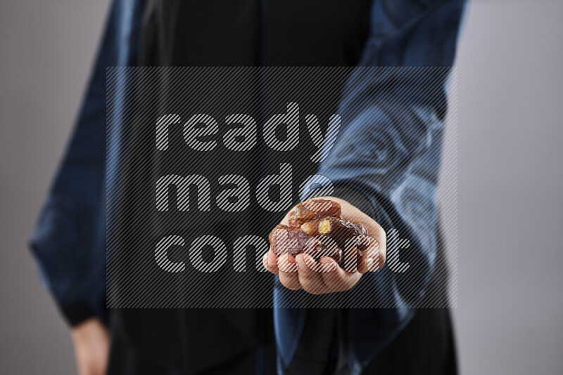 Woman in abaya holding dates in different positions