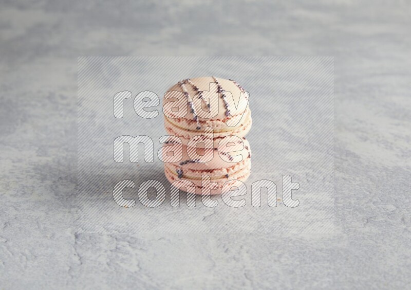 45º Shot of two pink orange blossom macarons  on white  marble background