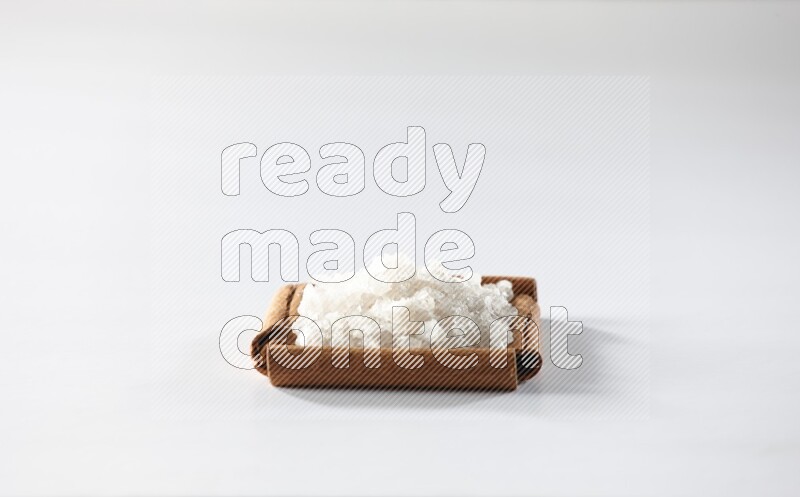 A single square of cinnamon sticks full of salt on white flooring