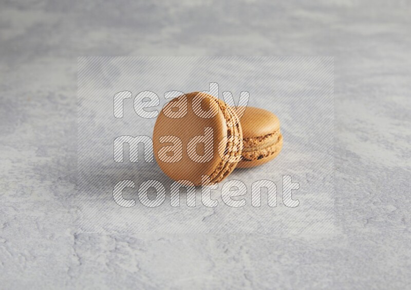 45º Shot of two Brown Maple Taffy macarons  on white  marble background