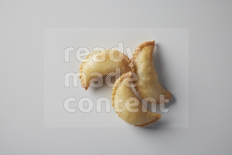 Three fried sambosa from a top angle on a white background