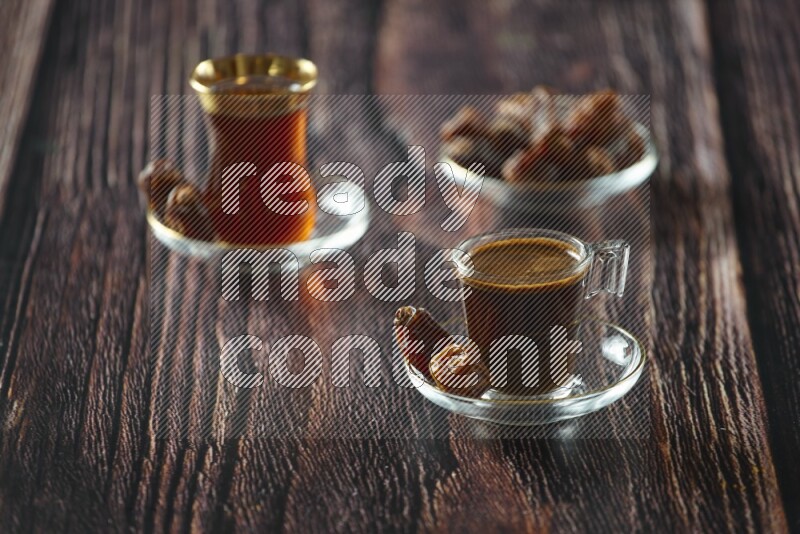 A coffee glass cup with dates and tea on wooden background