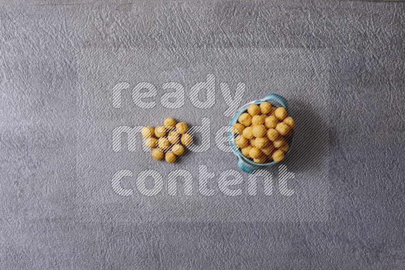 Assorted snacks in pottery bowls on grey background