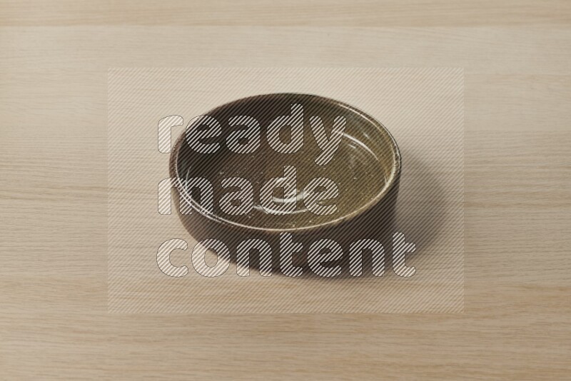 A multicolored pottery oven plate on light wooden background
