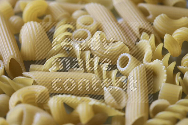 Different pasta types on light blue background