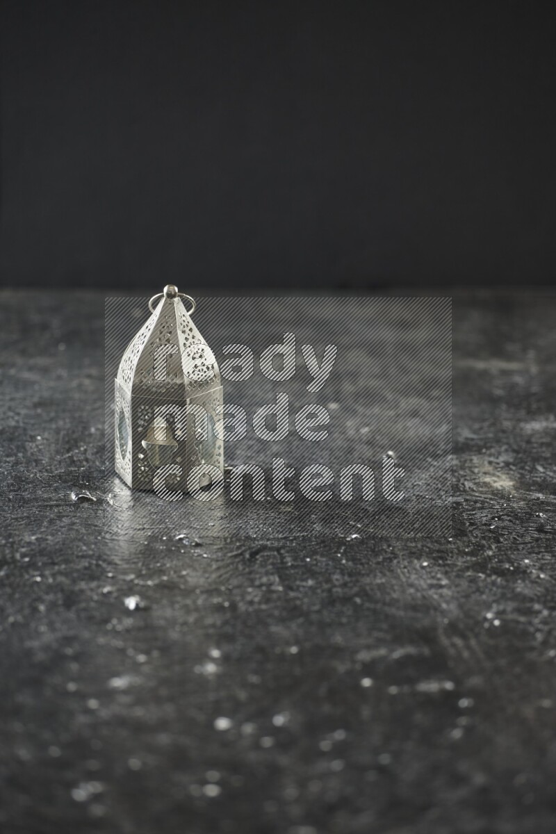 A lantern placed on a textured black background