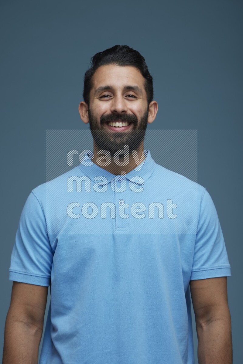 Man posing in a blue background wearing a Blue shirt