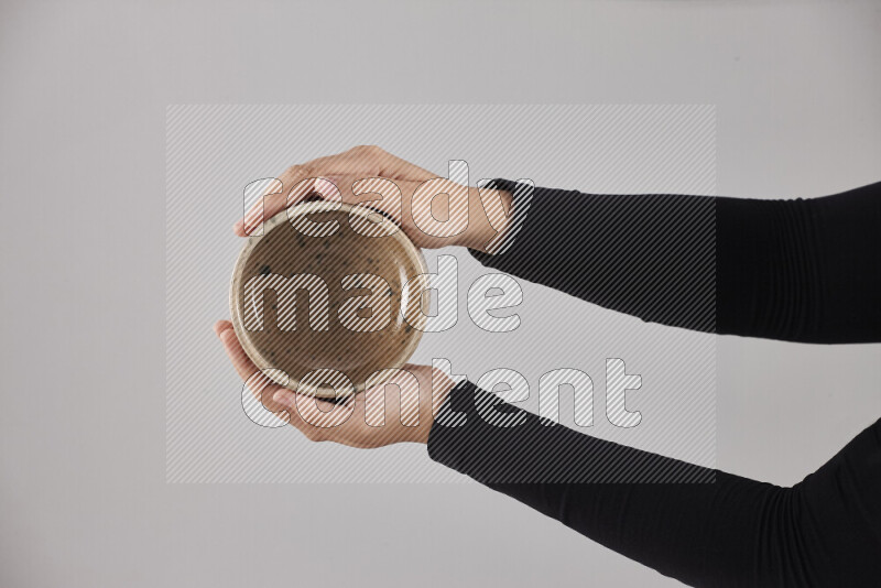 A woman in black abaya holding different pottery essentials in different positions