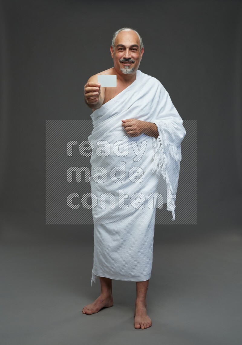 A man wearing Ehram Standing holding ATM card on gray background