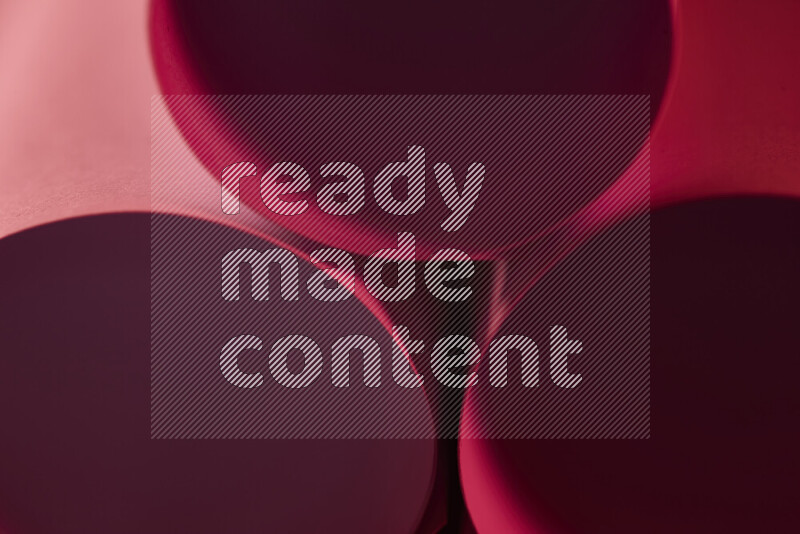 الصورة تعرض فن ورقي تجريدي بأشكال دائرية بدرجات متنوعة من اللون الأحمر