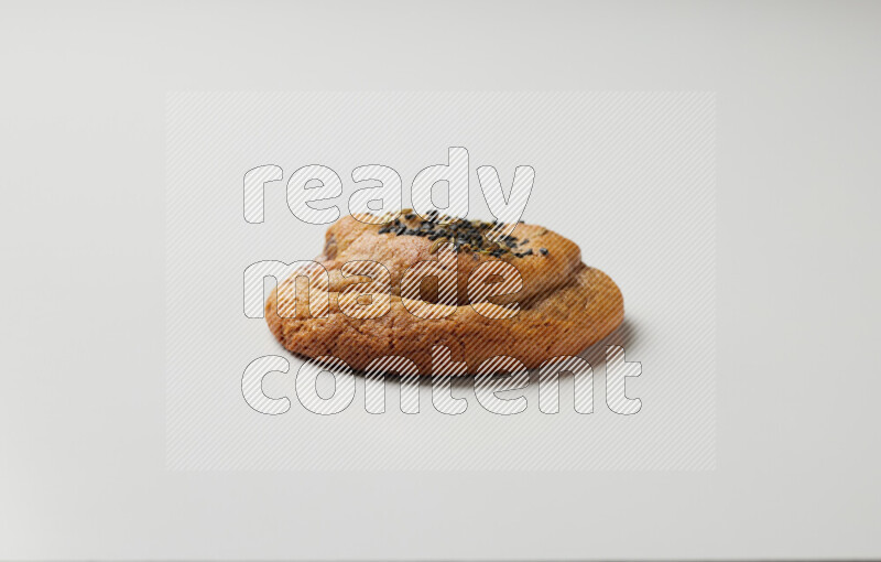 Hasawi cookie field with date and decorated by black seed and Anise grain on a white background