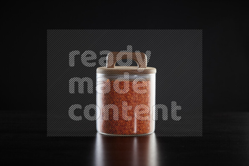 Lentils in a glass jar on black background