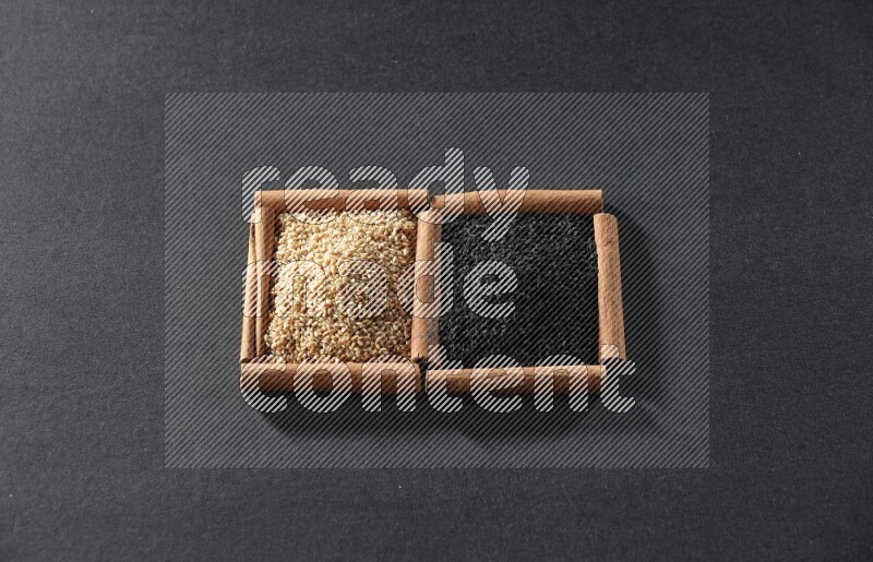 2 squares of cinnamon sticks full of sesame and black seeds on black flooring