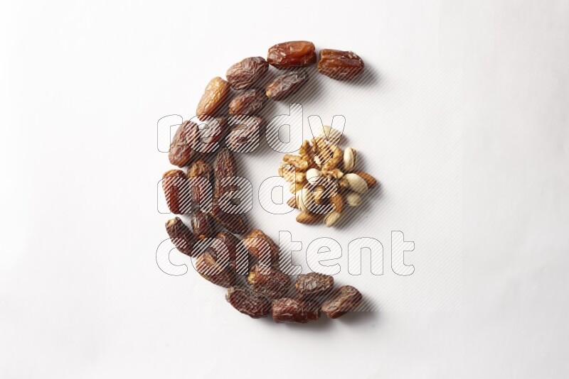 Dates in a crescent shape with nuts on white background