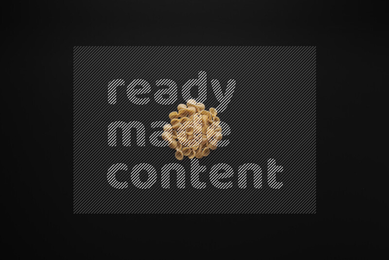 Different pasta types in bunches on black background