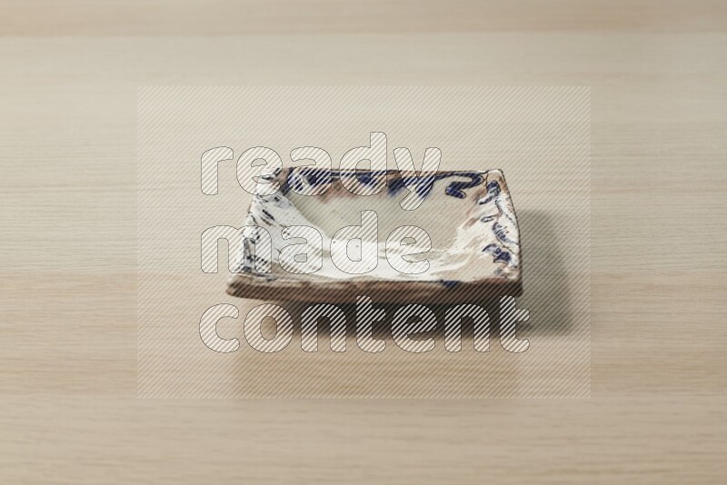 A decorative pottery plate on light wooden background