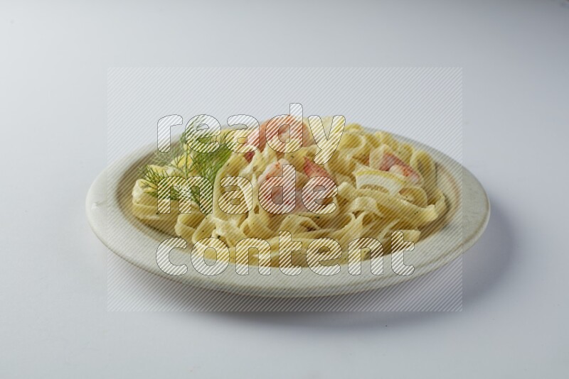 Fettuccini white sauce pasta with shrimp in a white plate on a white background
