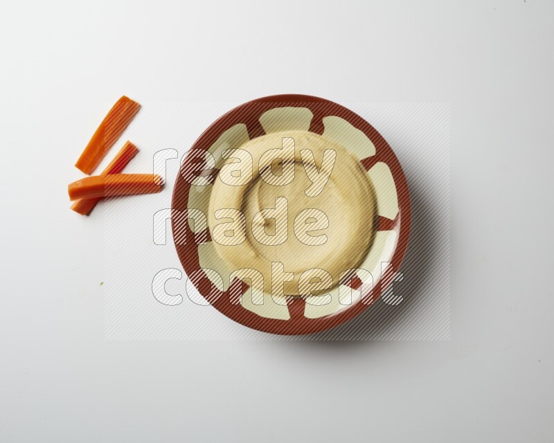 Plain hummus in a traditional plate on a white background