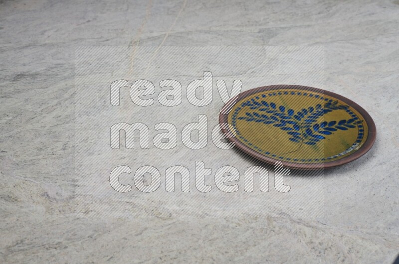 A decorative pottery plate on grey marble background