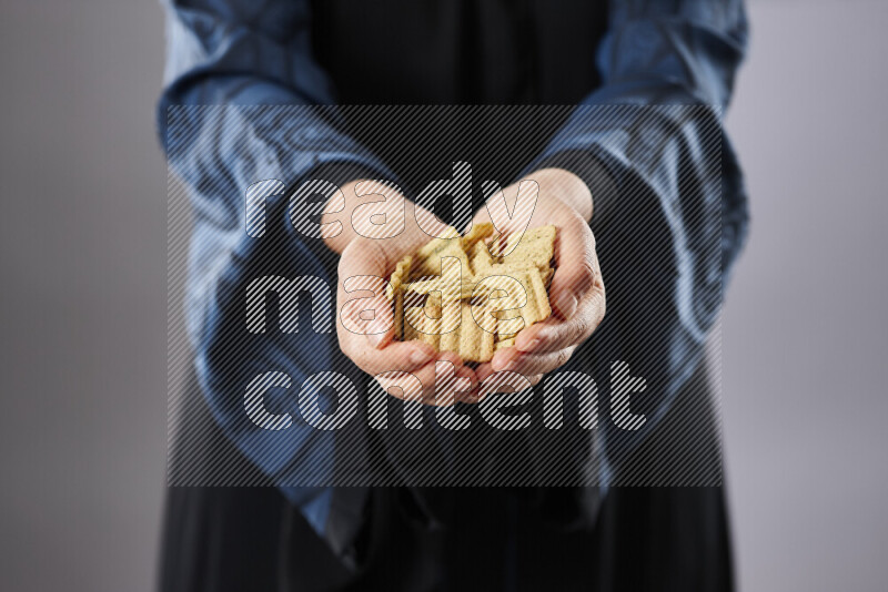 Woman in abaya holding different kinds of snacks in different positions