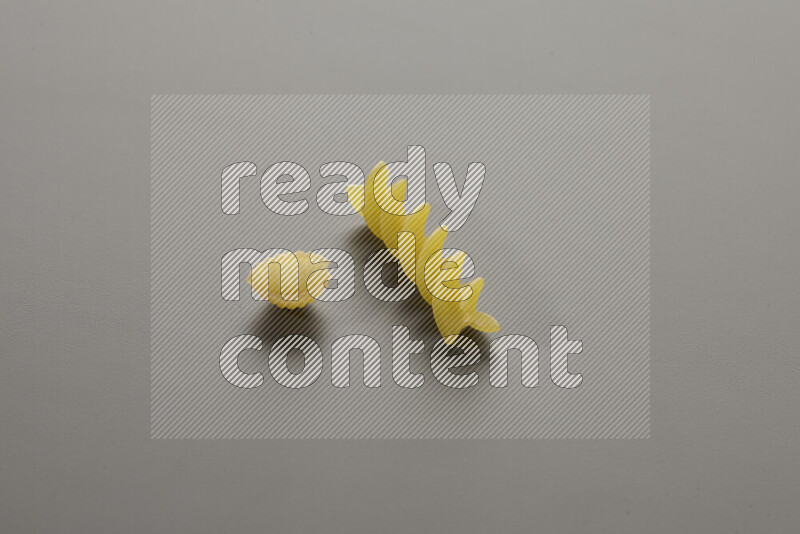 Shells pasta with other types of pasta on grey background