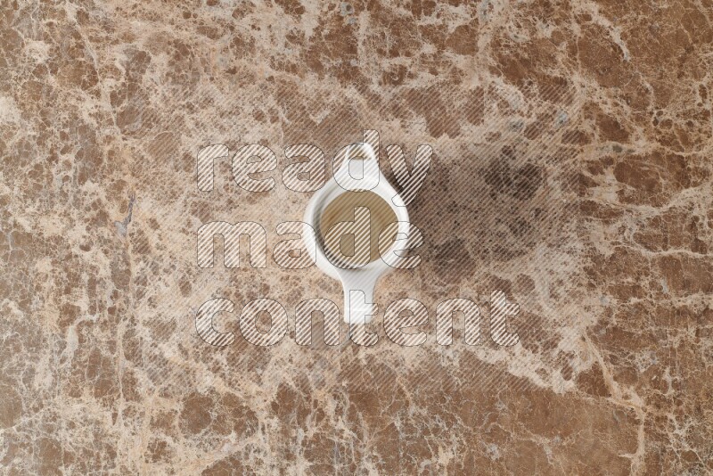 A ceramic milk jug on beige marble background