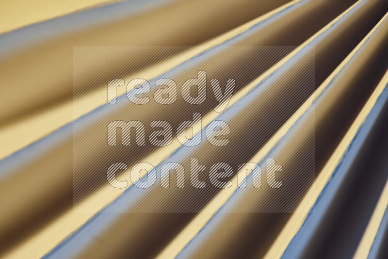 An image presenting an abstract paper pattern of lines in blue and gold tones