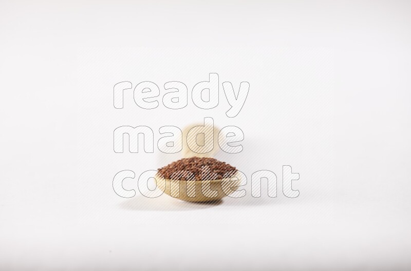 ملعقة خشبية ممتلئة ببذور حب الرشاد علي خلفية بيضاء