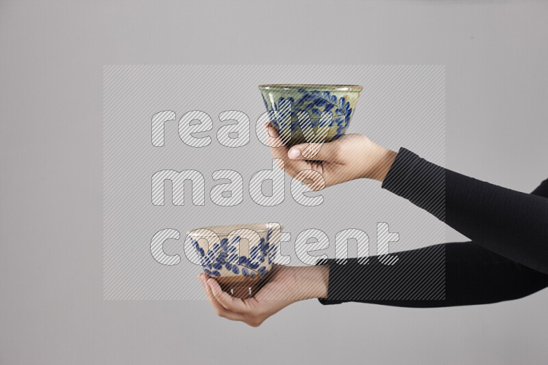 A woman in black abaya holding different pottery essentials in different positions