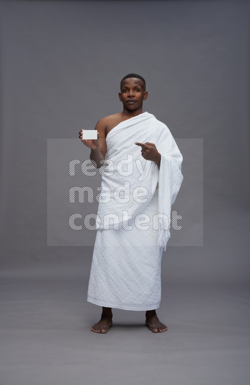 A man wearing Ehram Standing holding ATM card on gray background