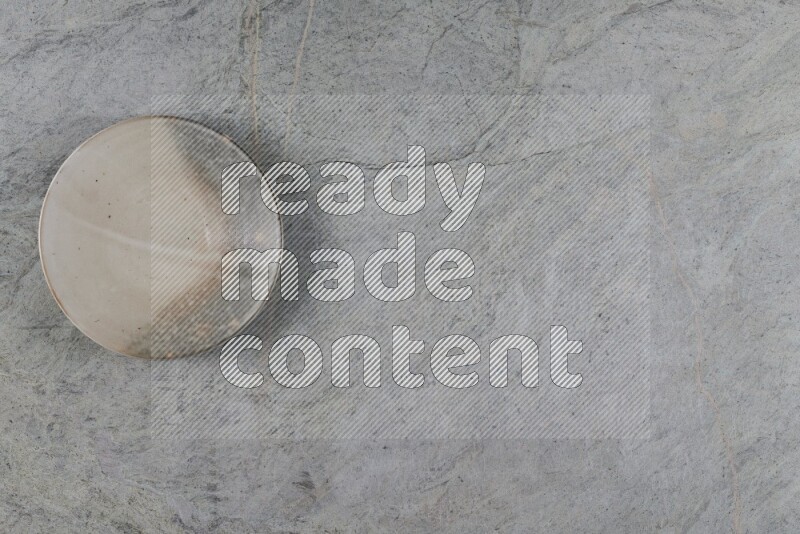 A multicolored pottery plate on grey marble background