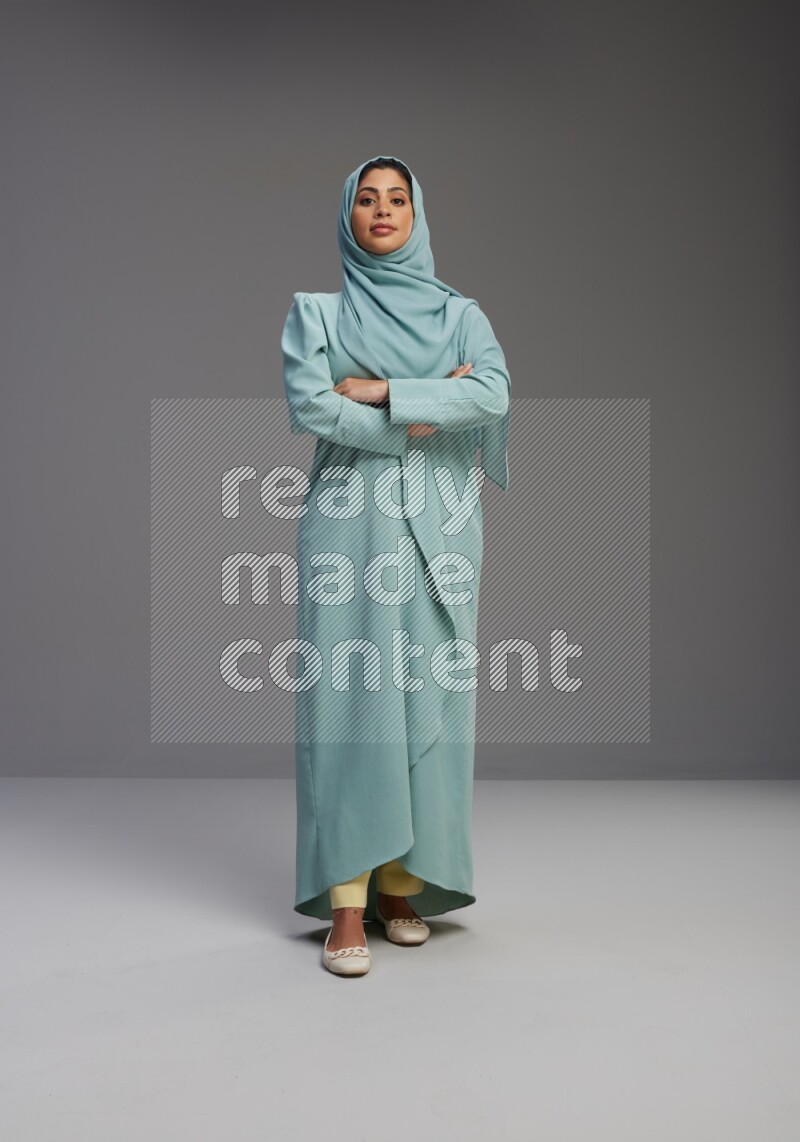 Saudi Woman wearing Abaya standing with crossed arms on Gray background