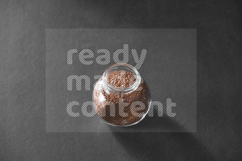 حبوب الكتان في وعاء زجاجي علي خلفية سوداء