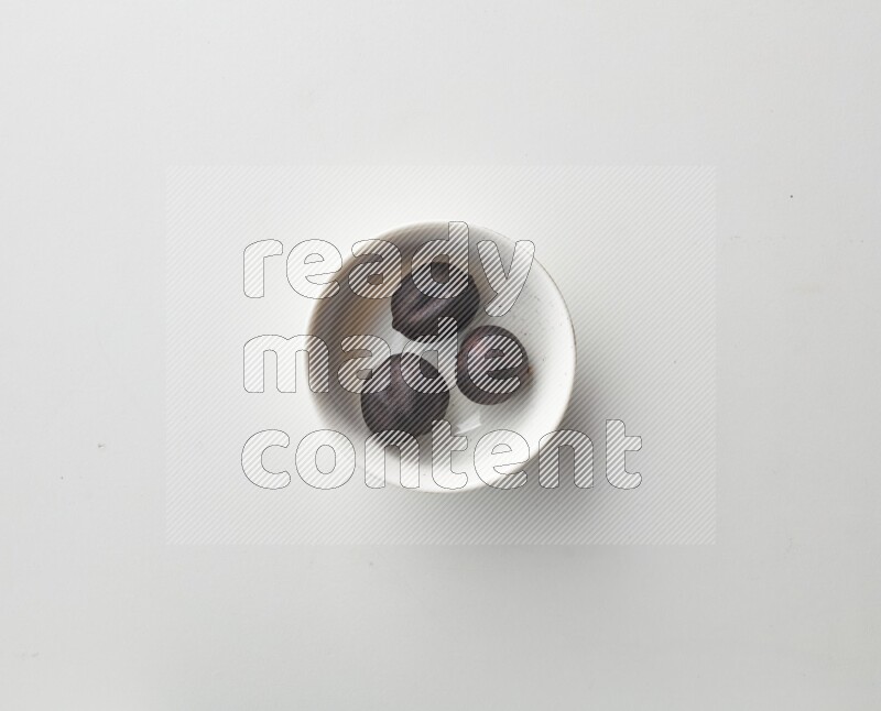 Top-view shot of dried lime (loomi) in a container on white background