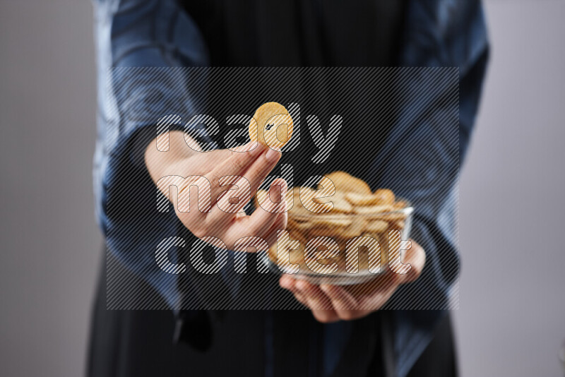 Woman in abaya holding different kinds of snacks in different positions