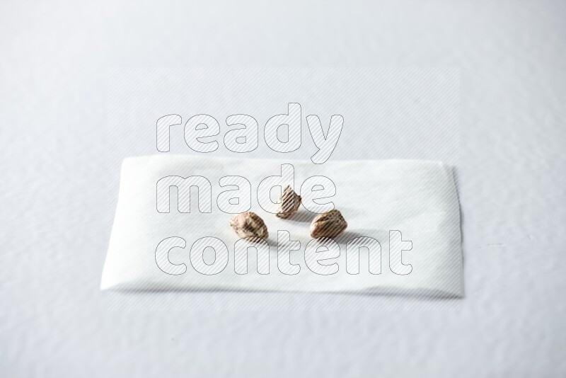 3 peeled pistachios on a piece of paper on a white background in different angles