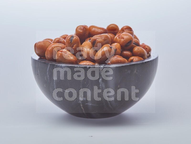 Close up shot of cooked fava beans (foul) in a container on white background