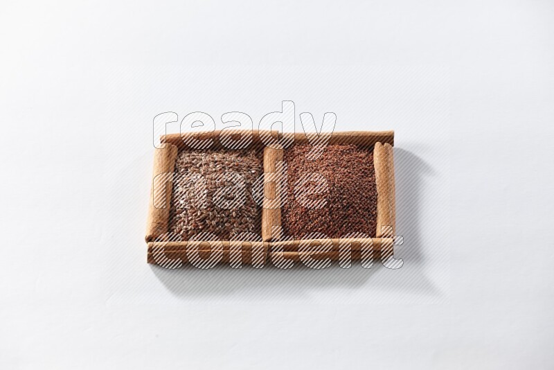 2 squares of cinnamon sticks full of flaxseeds and garden cress on white flooring