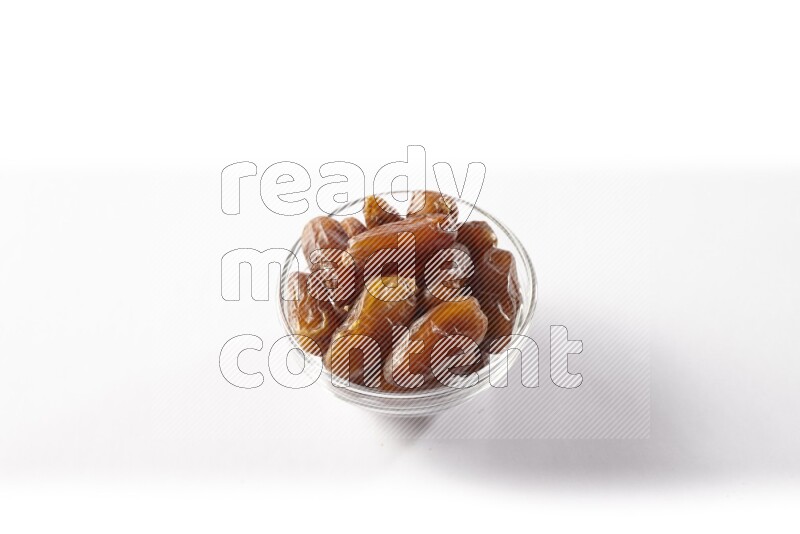 Dates in a glass bowl on white background