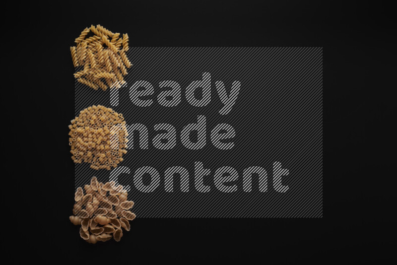 Different pasta types in 3 bunches on black background